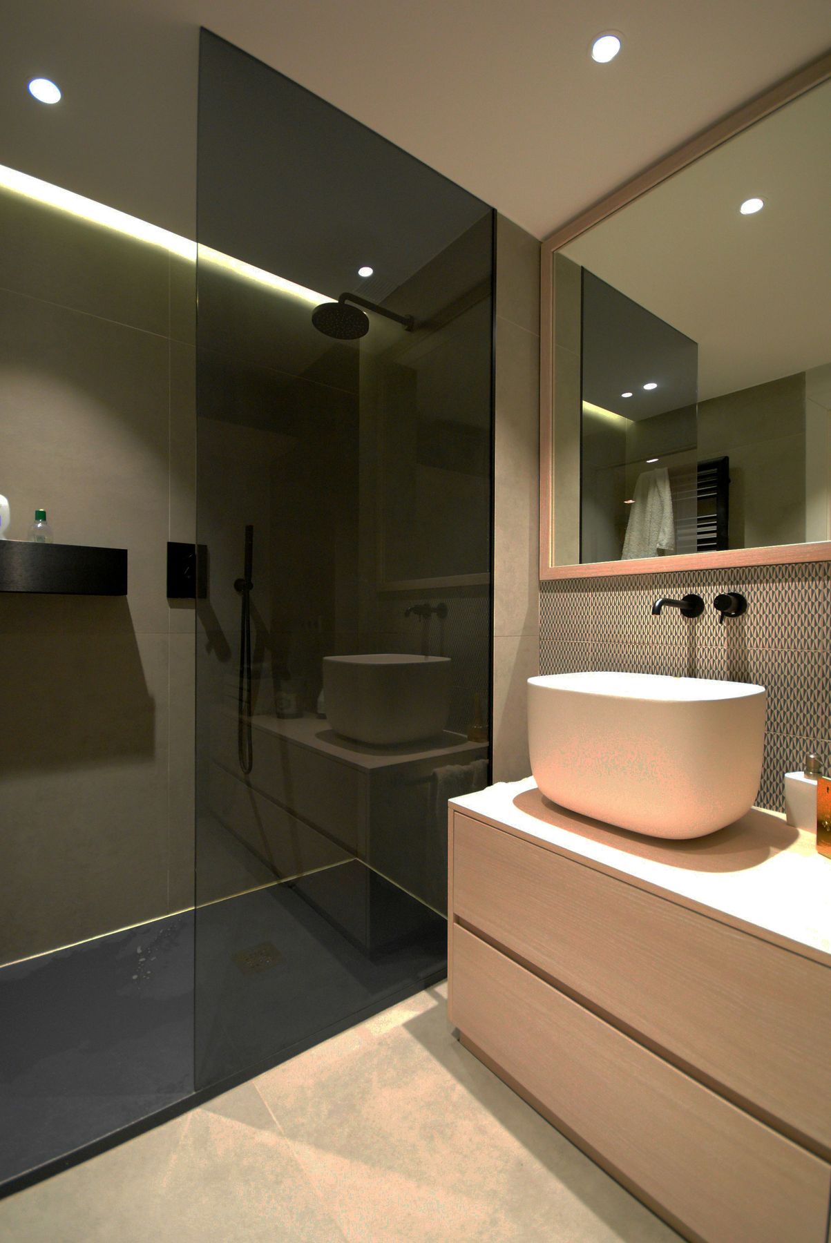 Stone-tiled ensuite bathroom with round mirror and black vessel sinks — The Meridian Suite, Fort Worth